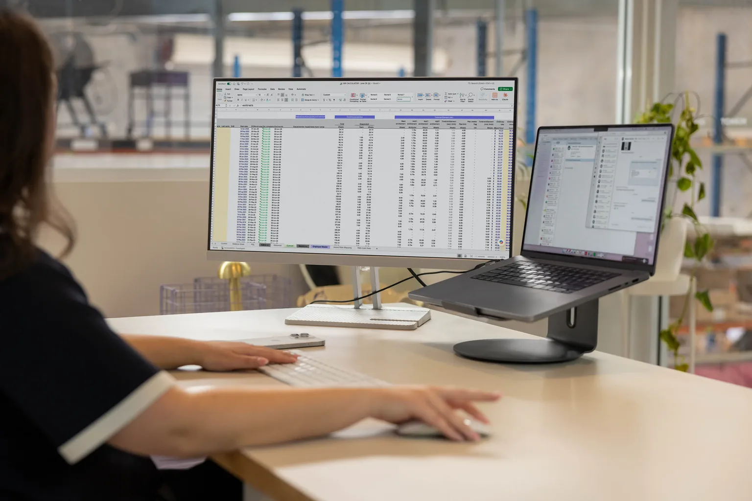 A Tonkin team member working across Microsoft 365 on a desktop and MacBook